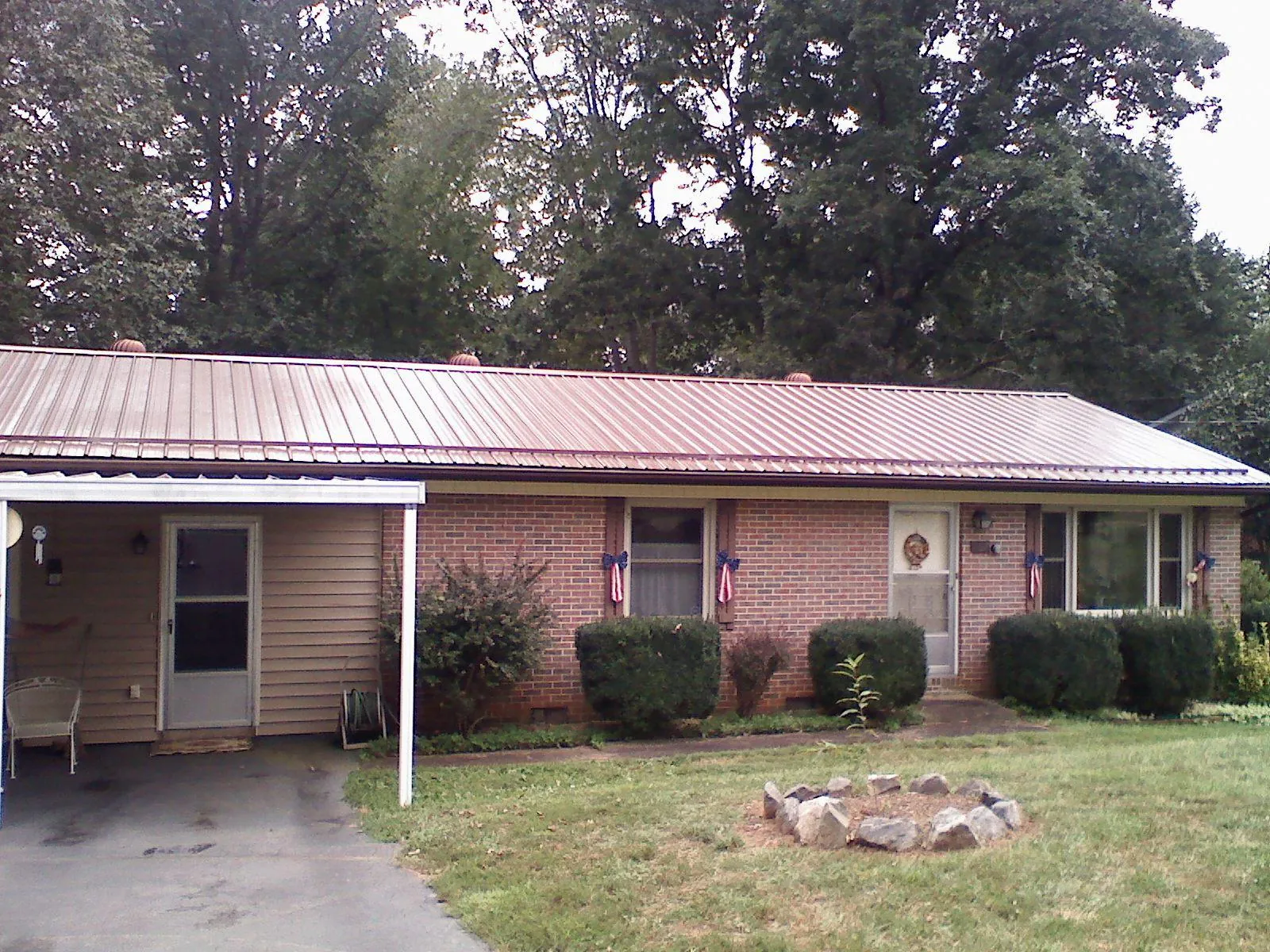 Bronze metal roof and carport on a brick ranch home — Roof Repair work by our crew in Knippa